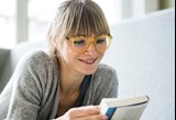 Image of female reading a book whilst wearing glasses 