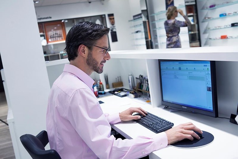 Male in pink shirt using computer